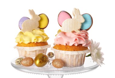 Beyaz arka planda lezzetli paskalya çörekleri ve yumurtaların yanında durun.