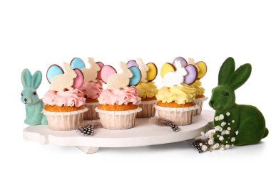 Lezzetli paskalya çörekleri ve beyaz arka planda tavşanları olan tahta.