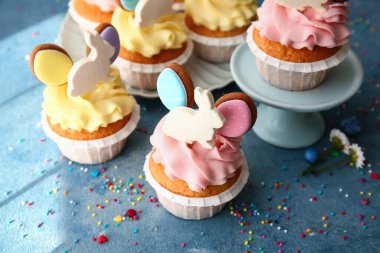 Lezzetli paskalya çörekleri ve renkli arka planda serpiştirmeler, yakın plan.