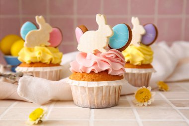 Renkli arka planda Paskalya çörekleri ve çiçekler, yakın plan.