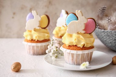 Lezzetli Paskalya çöreği tabağı ve arka planda çiçekler, yakın plan.