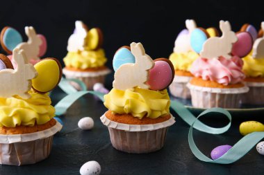 Lezzetli paskalya çörekleri ve koyu arkaplanda yumurtalar, yakın plan.