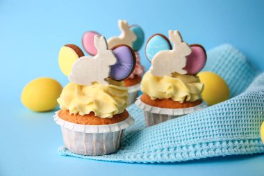 Lezzetli paskalya çörekleri ve yumurtalar mavi arka planda, yakın plan.