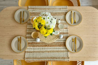 Uluslararası Kadınlar Günü kutlamaları için vazoda çiçekler ve yemek masası.