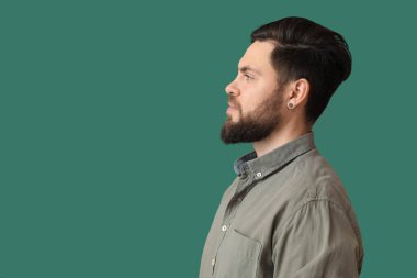 Yeşil arka planda şık sakallı adam.