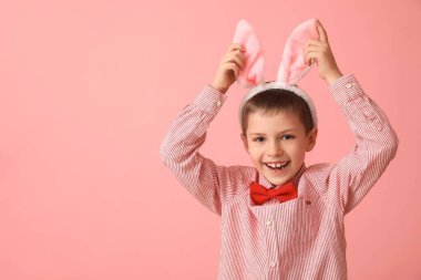 Pembe arka planda tavşan kulaklı komik küçük çocuk.