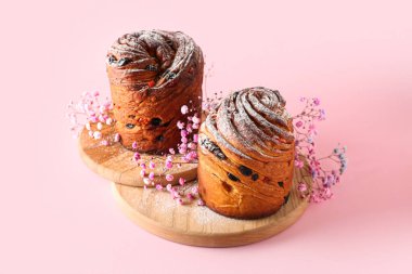 Lezzetli Paskalya pastaları ve pembe arka planda çingene çiçekleri olan ahşap tahta tahta.