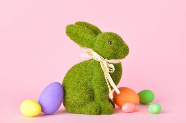 Tatlı Paskalya tavşanı ve pembe arka planda yumurtalar.