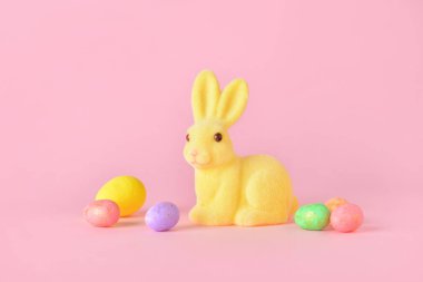 Tatlı Paskalya tavşanı ve pembe arka planda yumurtalar.