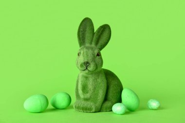 Tatlı Paskalya tavşanı ve yeşil arka planda yumurtalar.