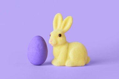 Mor arka planda şirin Paskalya tavşanı ve yumurta