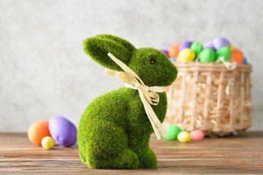 Paskalya tavşanı ve hasır sepeti, arka planda boyanmış yumurtalar.
