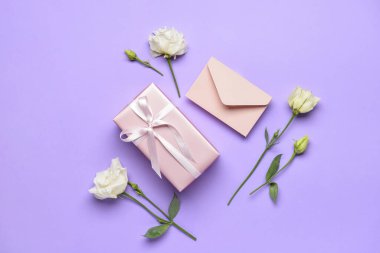 Hediye kutusu, zarf ve arkaplanda güzel çiçekler.