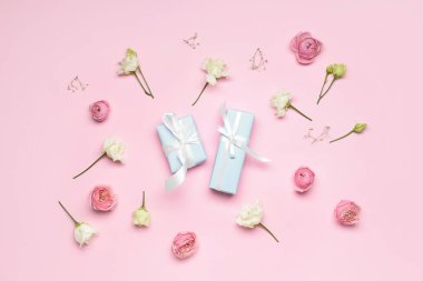 Renkli arkaplanda hediye kutuları ve çiçeklerle kompozisyon