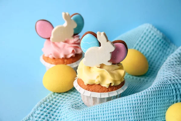 Lezzetli paskalya çörekleri ve yumurtalar mavi arka planda, yakın plan.