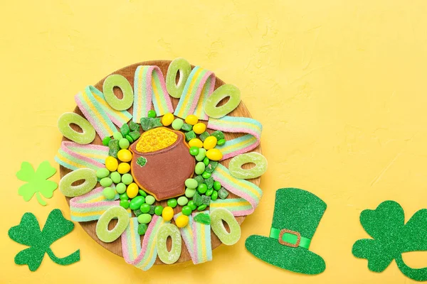 黄色背景的圣帕特里克节庆祝餐盘上有不同的糖果 — 图库照片
