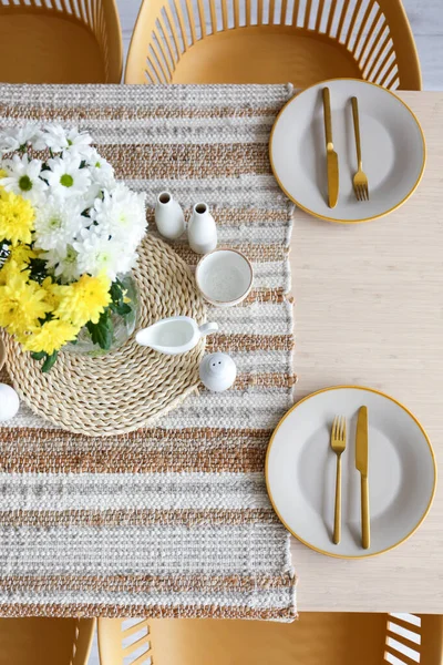 Uluslararası Kadınlar Günü kutlamaları için vazoda çiçekler ve yemek masası.