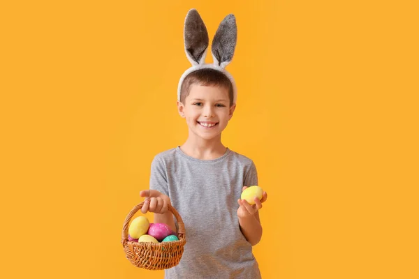 Zabawny Chłopczyk Króliczymi Uszami Wielkanocnym Koszykiem Żółtym Tle — Zdjęcie stockowe