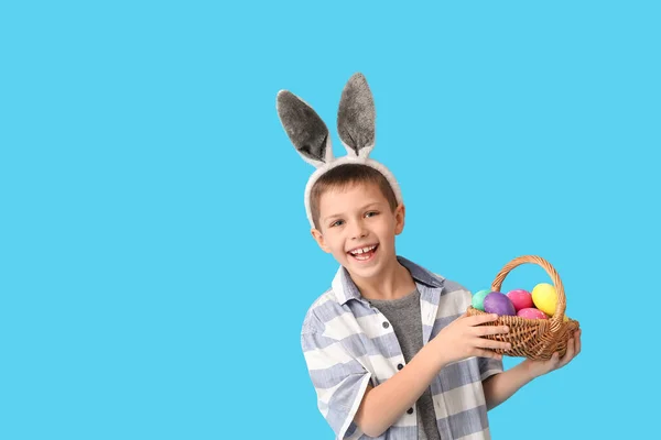 Zabawny Chłopczyk Króliczymi Uszami Koszykiem Wielkanocnym Niebieskim Tle — Zdjęcie stockowe