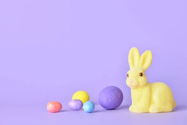 可爱的复活节兔子和紫色背景的蛋 — 图库照片