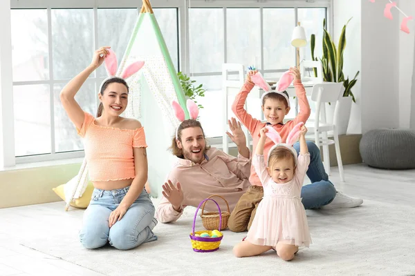 Evde paskalya yumurtaları ve tavşan kulakları olan mutlu bir aile.