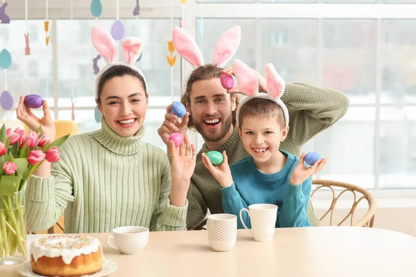 Mutlu ebeveynler ve Paskalya yumurtaları masada oturan küçük oğulları.