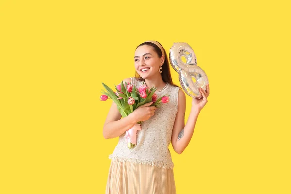 黄色の背景に図8の形をした花束と風船を持つ幸せな若い女性 国際女性デー — ストック写真