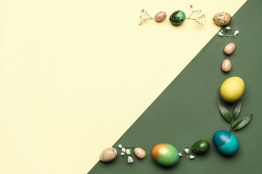 Renkli arka planda Paskalya yumurtası ve çiçekleriyle kompozisyon