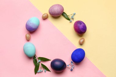 Renkli arkaplanda Paskalya yumurtası ve çiçeklerinden yapılmış çerçeve