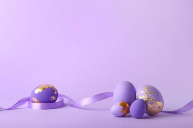 Mor arkaplanda zarif Paskalya yumurtaları ve kurdele
