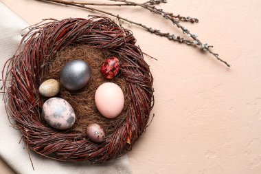 Renkli arka planda boyanmış Paskalya yumurtaları olan yuva