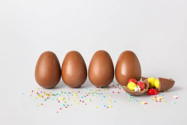 Lezzetli çikolatalı Paskalya yumurtaları ve hafif arka planda farklı şekerler.