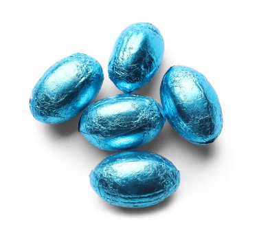 Beyaz arka planda mavi folyoya sarılı Paskalya yumurtaları