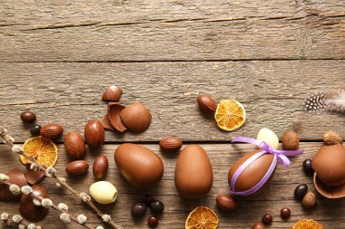 Composition with chocolate Easter eggs and pussy willow branches on wooden background