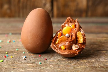 Kırık paskalya yumurtası, ahşap masada farklı şekerlemeler, yakın plan.