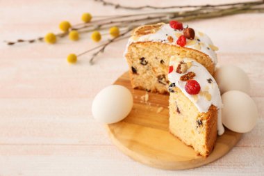 Lezzetli Paskalya pastaları ve beyaz ahşap arka planda yumurtaları olan tahta.