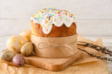 Lezzetli Paskalya pastası ve beyaz ahşap arka planda yumurtalar.