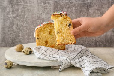 Gri arkaplanda lezzetli paskalya pastası tutan bir kadın.