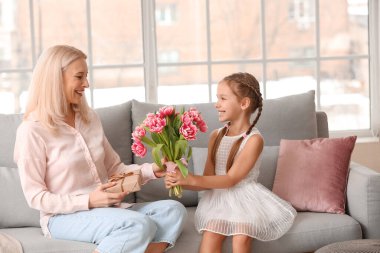 Küçük kız Uluslararası Kadınlar Günü 'nde büyükannesini lalelerle selamlıyor.