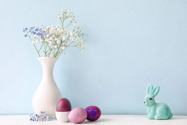 Összetétel Húsvéti Tojással Nyuszival Virágokkal Asztalon Színes Fal Mellett — Stock Fotó