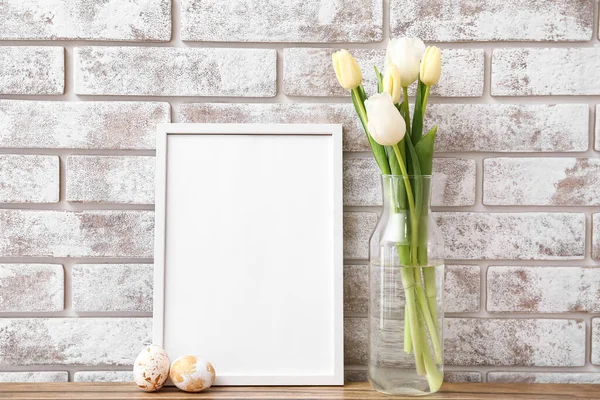 Composition Photo Frame Easter Eggs Flowers Table Light Brick Wall — Stock Photo, Image