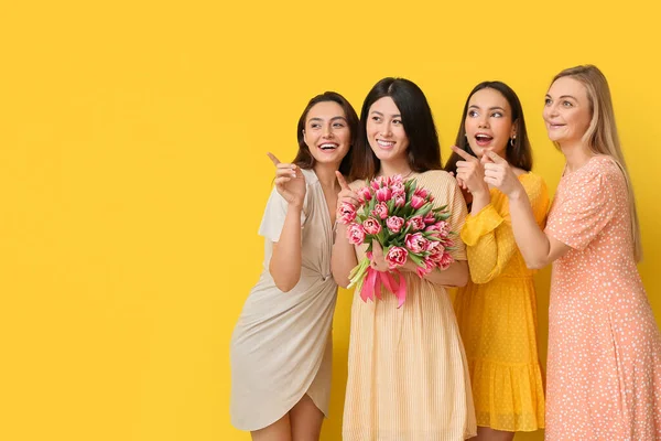 Belle Donne Con Mazzo Fiori Che Puntano Qualcosa Sfondo Giallo — Foto Stock