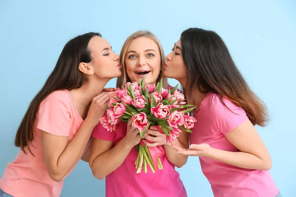 年轻女孩亲吻成熟的女人 蓝色背景的花朵 国际妇女节庆祝活动 — 图库照片