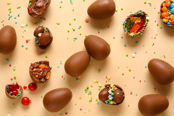 チョコレートイースターエッグとの組成 ベージュの背景に異なるキャンディーやスプリンクル — ストック写真