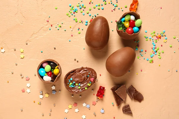 チョコレートイースターエッグ キャンディー スプリンクルとベージュの背景 — ストック写真