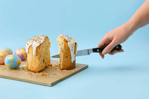 Woman Cutting Delicious Easter Cake Blue Background — Stock Photo, Image