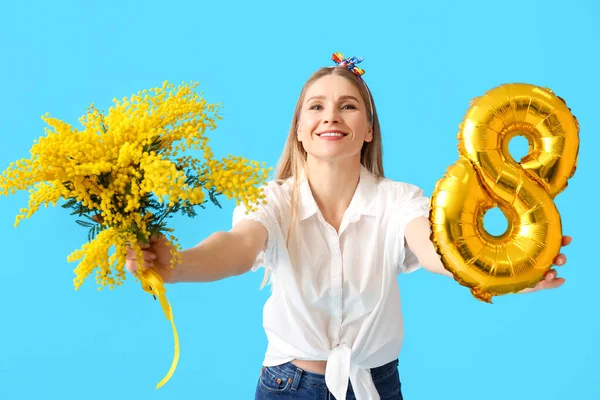 Şekil 8 şeklinde balonu ve mavi arka planda mimoza çiçekleri olan güzel bir kadın. Uluslararası Kadınlar Günü