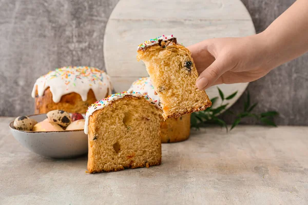 Gri arkaplanda lezzetli paskalya pastası tutan bir kadın.