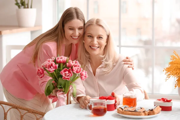 Young Woman Greeting Her Mother Bouquet Tulips Kitchen — Stock Photo, Image