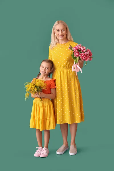 Büyükannesi Yeşil Arka Planda Çiçekleri Olan Küçük Bir Kız — Stok fotoğraf